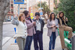 © Tatiana - Group of People looking and talking on phones at the same time outdoors