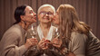© master1305 - Happy Mothers day. Two elderly women, daughter's greeting their old mother with her day, drinking wine, laughing, showing respect and love. Concept of elderly lifestyle, positive emotions