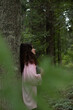 © Victoria Kluy - Woman holding green leaf in forest. Nature harmony and mental wellness scene