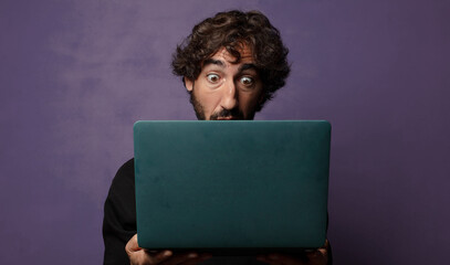 young bearded crazy man with a laptop