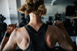 © Rob and Julia Campbell/Stocksy - Muscular Woman Lifting Dumbbells in Gym Workout Session