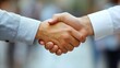© Pat J. - Close-up of a firm handshake between two business partners, emphasizing collaboration and trust