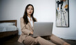 © RooftopStudioBangkok - Business woman working on laptop in modern office setting, exuding professionalism and focus. minimalist background enhances contemporary atmosphere