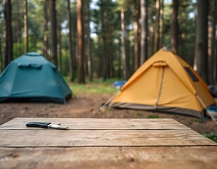 Wall Mural - A empty wooden table in the foreground with a tent and trees in the blurred background, suggesting an outdoor camping scene in a forest