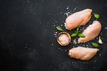 Wall Mural - Chicken fillet, raw chicken meat breast with spices and herbs at dark background. Top view with space for text.