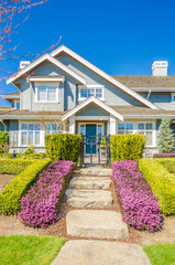 Wall Mural - Entrance of grey painted luxury house in summer with stair steps and nice landscape in Vancouver, Canada, North America. Day time on June 2024.