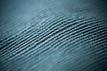 That's a close-up macro shot of a textured fabric, showing parallel, slightly wavy ridges.  The color is a muted teal or blue-gray.