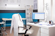 © DC Studio - Empty medical office with no people inside, having clinical equipment and computer ready for healthcare use. Modern desktop pc in vacant hospital room displaying patient diagnostic data.
