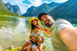 © unai - Family taking selfie at lake dobbiaco in the dolomites, italy