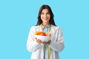 Sticker - Female nutritionist with healthy food on blue background