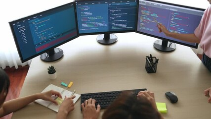 Slow motion back end software developer engineer for computer programming working together on debugging writing computing code, solving complex algorithms display on monitor in office. Burgeoning