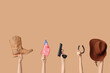 © Pixel-Shot - Female hands with cowboy accessories, gun and flag of USA on color background