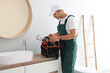 © Pixel-Shot - Male plumber with bag of tools in bathroom