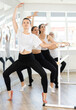 © JackF - Group of dancers standing in grand plie ballet position in bright fitness room