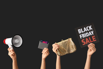 Wall Mural - Female hands with megaphone, credit card and stylish bag on dark background. Black Friday Sale