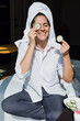 © Marcos - Latin adult woman applying facial mask on face with cucumber slices for exfoliation at home in Mexico Latin America, hispanic people