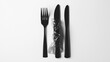 © Sabana - Black cutlery arranged on a white surface with plastic wrap