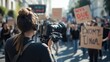 © Endin - Woman filming a protest march in the city street.