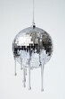 © Fauzi - A disco ball dripping with silver liquid, on a white background