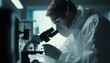 © Ytnart - A focused scientist in protective gear examines specimens under a microscope in a modern laboratory, showcasing the importance of research and innovation in scientific discovery.