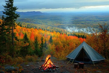 a campfire crackling beside a tent on a hilltop, with a wide view of a vibrant autumn forest in full