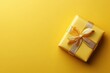 © saleem - Yellow gift wrapped in ribbon on a bright yellow background
