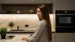 © uros - Young Woman Enjoying a Cozy, Stylish Modern Kitchen with Bright Lighting, Natural Decor, and Contemporary Appliances, Embracing a Relaxed Morning Routine