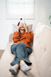 © Fahng - young asian woman with headphones at home listen music online happy smile hold mobile phone smartphone use app application sit on the sofa ,audiobook or radio podcast