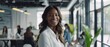 © Ai Studio - A smiling woman in a modern office, radiating approachability and contentment amidst a busy workspace.