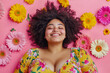 © Lazy_Bear - Plus-size model lying on pink background with flowers. Smiling woman with overweight enjoying life. Concept of self love and body positive