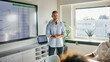 © Flamingo Images - Business Presentation in Modern Office with Data Analysis on Screen. A mature businessman, with a hint of gray in his hair, wearing a blue shirt, stands in front of his colleagues and speaks.