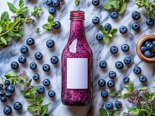 Wall Mural - A vibrant smoothie bottle surrounded by fresh blueberries and mint leaves on a marble surface.