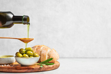 Pouring Olive Oil over Green Olives