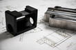 © juraj - Plastic and metal prototypes are lying on a technical drawing with measurements, showcasing the process of product development
