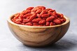 © Marina Demidiuk - Goji berries. Wolfberry bowl on a concrete background. Dried goji berries in bowl on textured table, closeup. Space for text. Superfood. Dried goji berry preparations ayurvedic medicine ingredients.