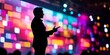 © Angelo - A male speaker silhouetted against a vibrant, colorful background during a dynamic presentation.