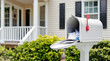 © Evgen - Open mailbox with letters and flyers in front of a house, illustrating suburban postal service