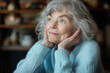 © Vasili - Elderly woman sitting indoors, gazing thoughtfully into the distance with a soft, warm light. Represents wisdom, memories, and a sense of nostalgia.