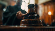© sajid Pixel - Partial view of a blurred judge holding a gavel during sentencing in court.