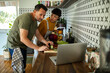 © Geber86 - Multicultural couple cooking together while following a recipe on laptop in stylish kitchen