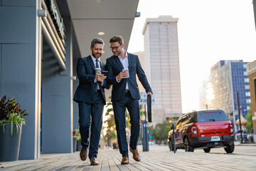 Colleague walk in New York. Success. Businessmen in suit walking outdoor. Two businessmen walking and talking in the city. Business men talking. Walking and talking two business men. Advertisement