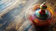 © Artyom - Vibrantly painted spinning top in motion on wooden surface