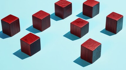 Wall Mural - Stylized arrangement of red and black wooden cubes casting shadows on a light blue background for artistic abstract composition