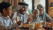 © sajid Pixel - Smiling Middle Eastern family talking during Ramadan breakfast at home.