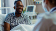 © sajid Pixel - Smiling patient chatting with a doctor while sitting on a bed in a hospital.