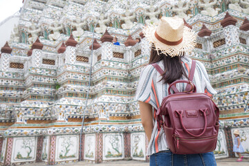 Wall Mural - Asian girl tourist smiling while visiting Wat Arun or Temple of Dawn backpacker women