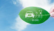 © chiew - ECO Car clean energy alternative future concept. Hand holding green leaf with EV electric vehicle, renewable energy carbon reduction, Ecology environment en