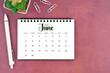 © Southtownboy Studio - June desk calendar for 2025 year and pen on old red cover. Flat lay.