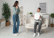 © Pixel-Shot - Young couple with modern robot vacuum cleaner in living room