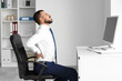 © Pixel-Shot - Young businessman suffering from back pain at table in office